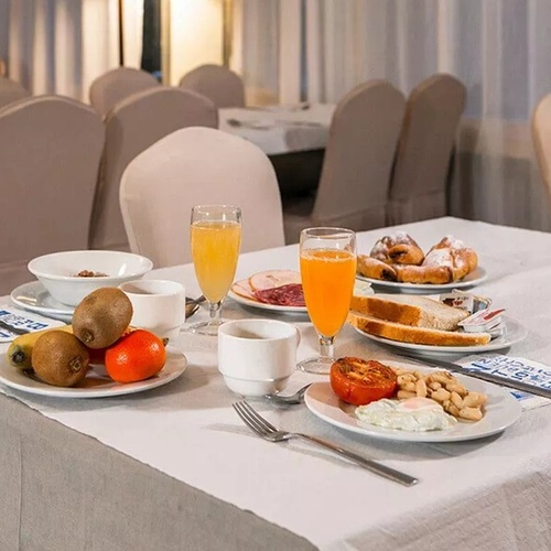 una mesa cubierta con platos de comida y un vaso de jugo de naranja