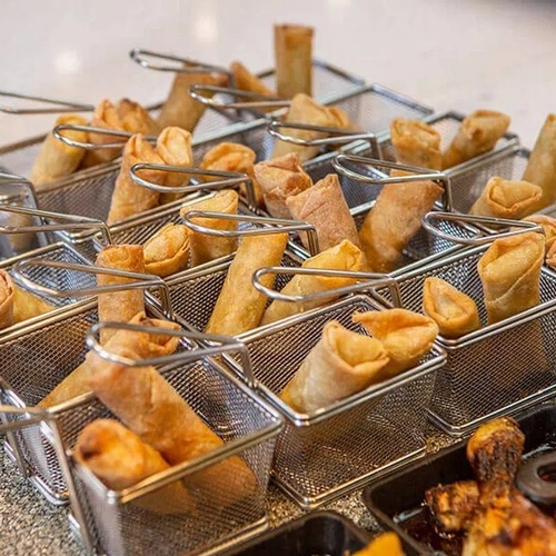 una fila de canastas llenas de rollos de primavera y pollo frito