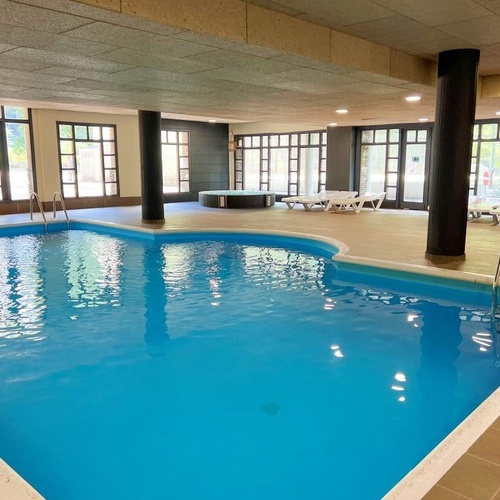 una piscina dentro de un edificio con muchas ventanas