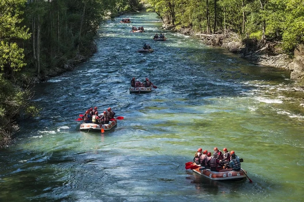 a group of people are rafting down a river and one of their rafts has the word raft on it