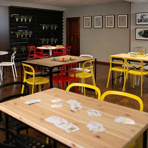 une salle de jeux avec des tables et des chaises colorées