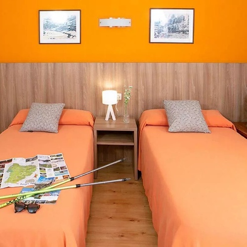 une chambre avec deux lits et un sac à dos