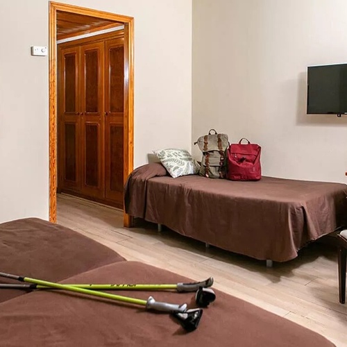 une chambre avec deux lits , une chaise et une télévision