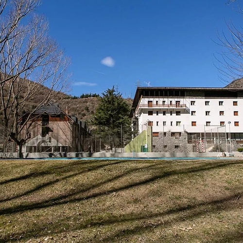 un gran edificio blanco está rodeado de árboles y hierba