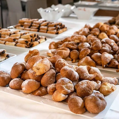 un montón de pasteles cubiertos con azúcar en polvo están sobre una mesa .