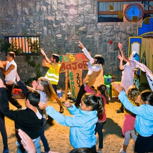 un grupo de niños bailan frente a un cartel que dice 