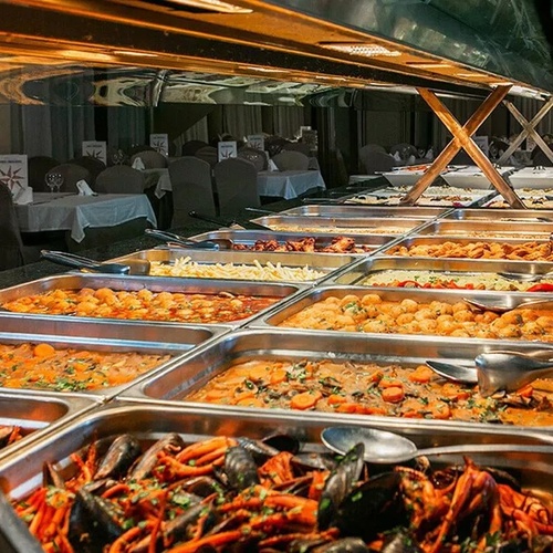 un buffet lleno de platos y cubiertos en un restaurante