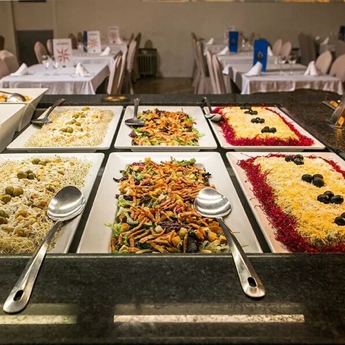 un buffet con platos de comida y cucharas en un restaurante