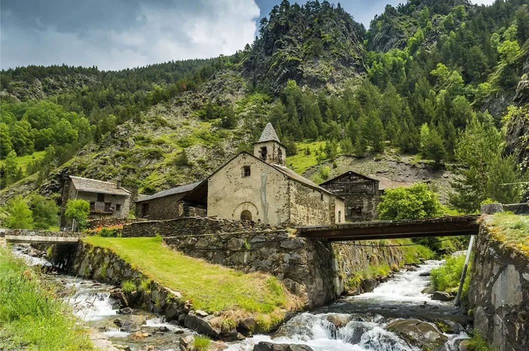 a snowy mountain landscape with a cabin in the foreground