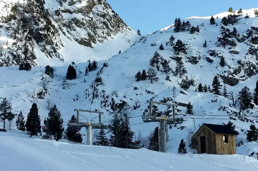 une maison en bois est assise au sommet d' une montagne couverte de neige