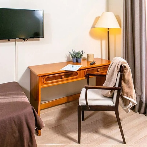 une télévision samsung est accrochée au mur à côté d' un bureau en bois