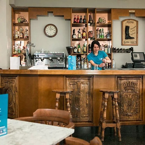 une femme prépare un cocktail au comptoir d' un bar