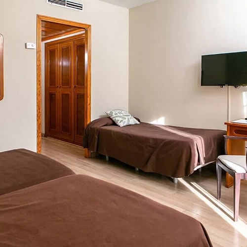 une chambre avec deux lits , une chaise et une télévision