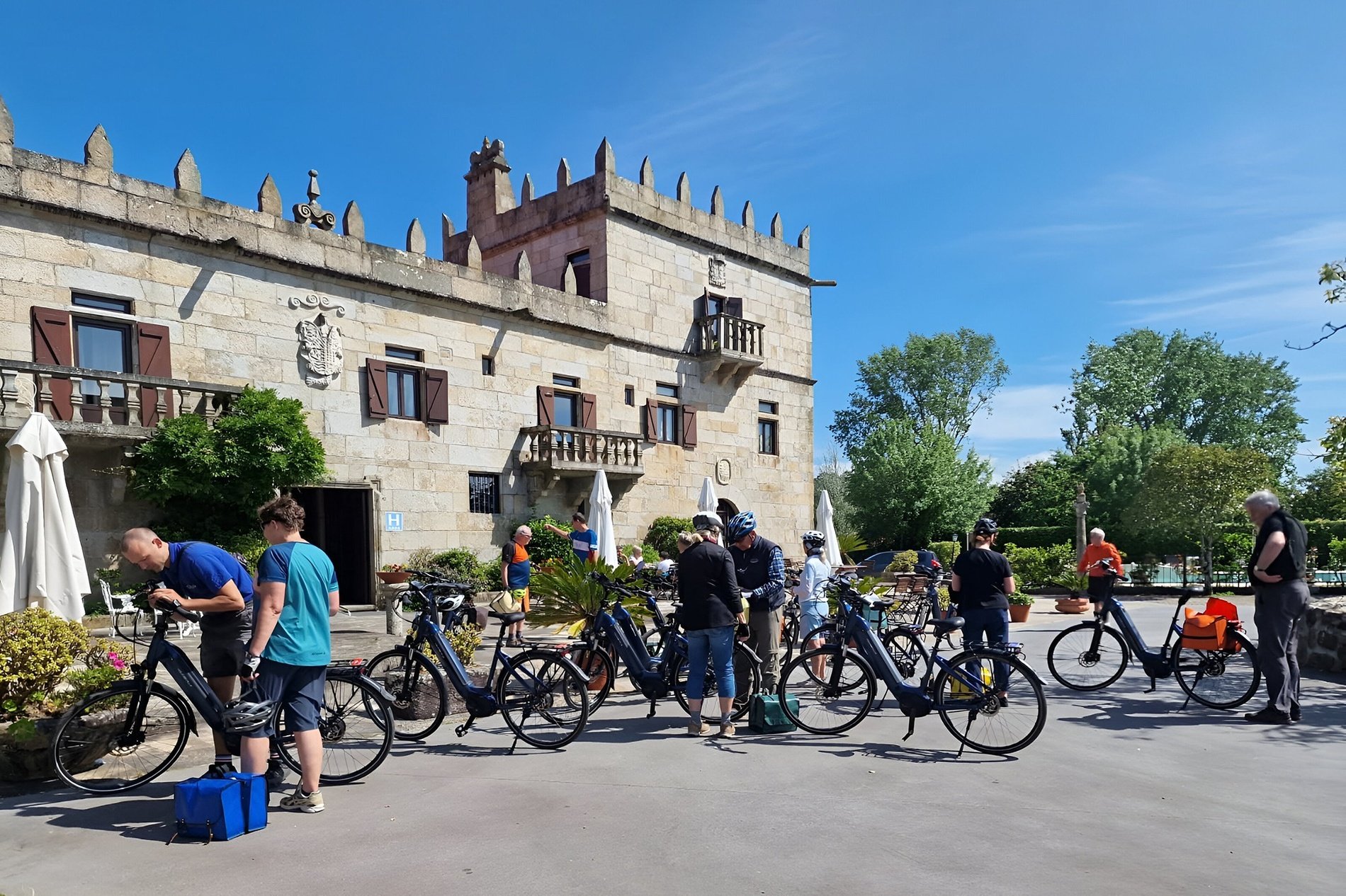 a group of people riding bicycles in front of a castle