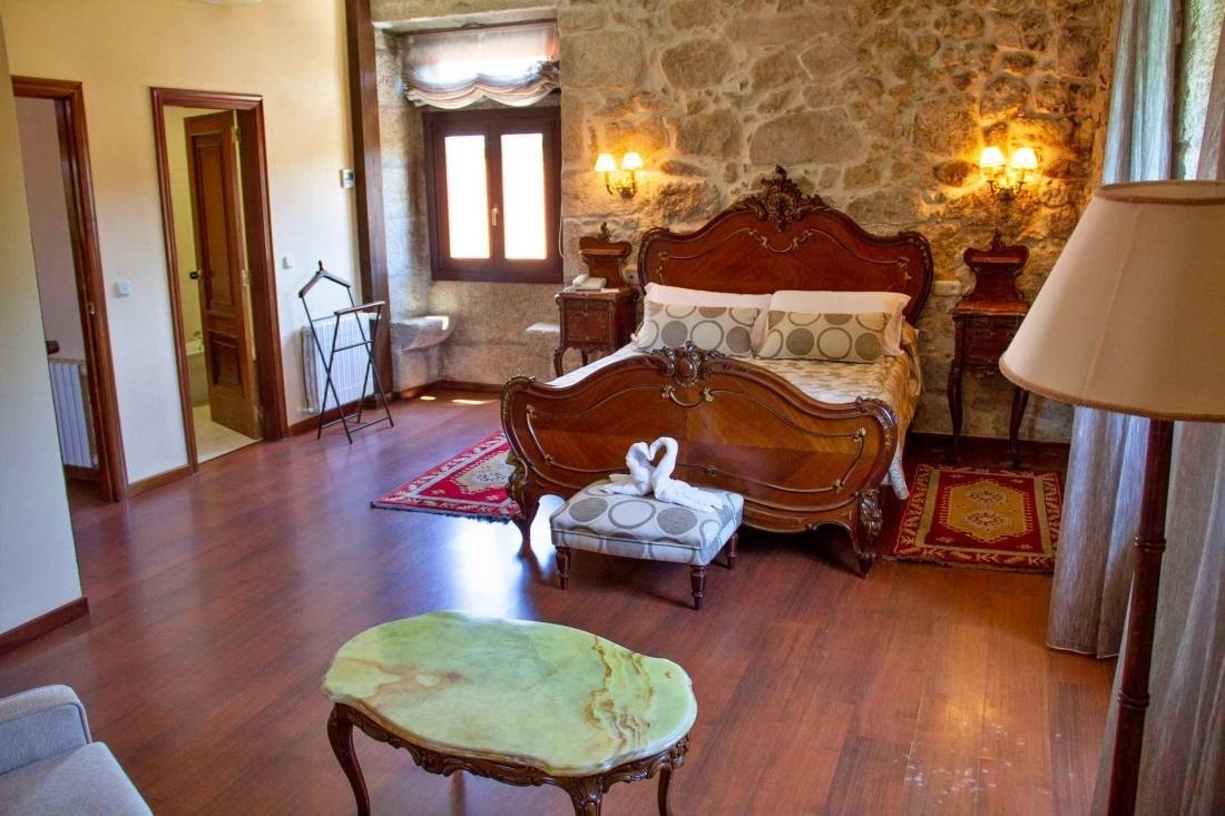 une chambre avec un lit en bois et une table en marbre
