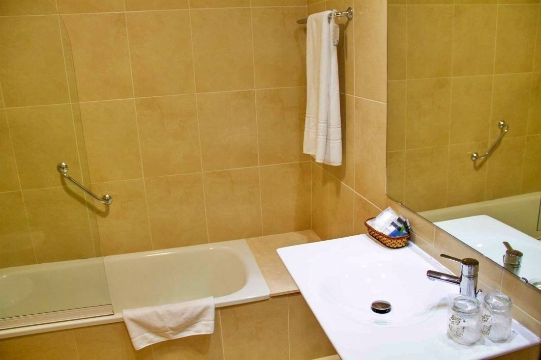 a bathroom with a sink a tub and a mirror