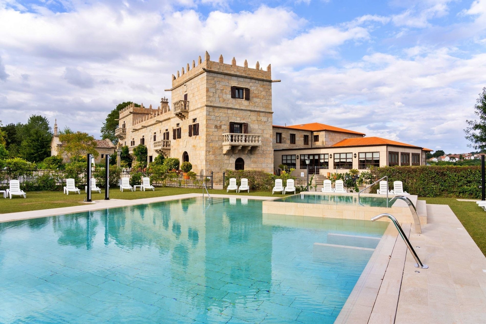 a swimming pool in front of a large stone building