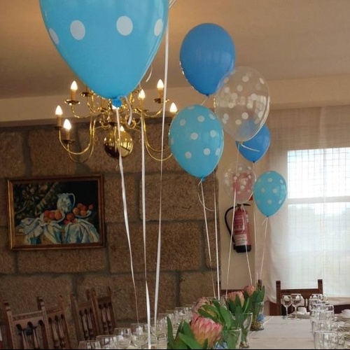 blue and white polka dot balloons are hanging from the ceiling