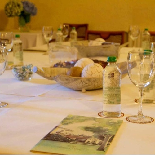 a table set with bottles of water and wine glasses