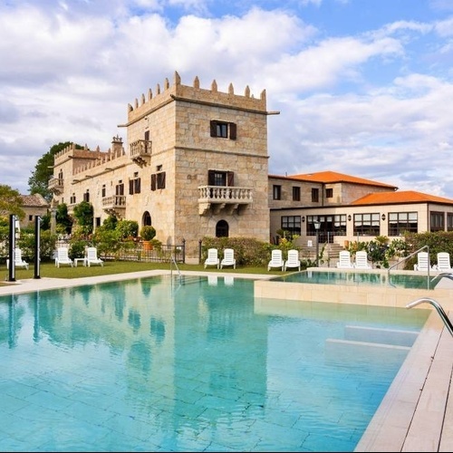 una piscina frente a un gran castillo de piedra