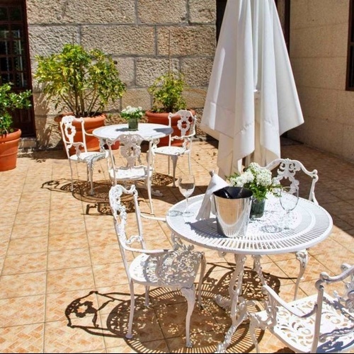 une terrasse avec des tables et des chaises et un parapluie