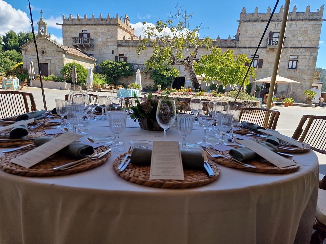 una mesa con platos y copas en frente de un castillo