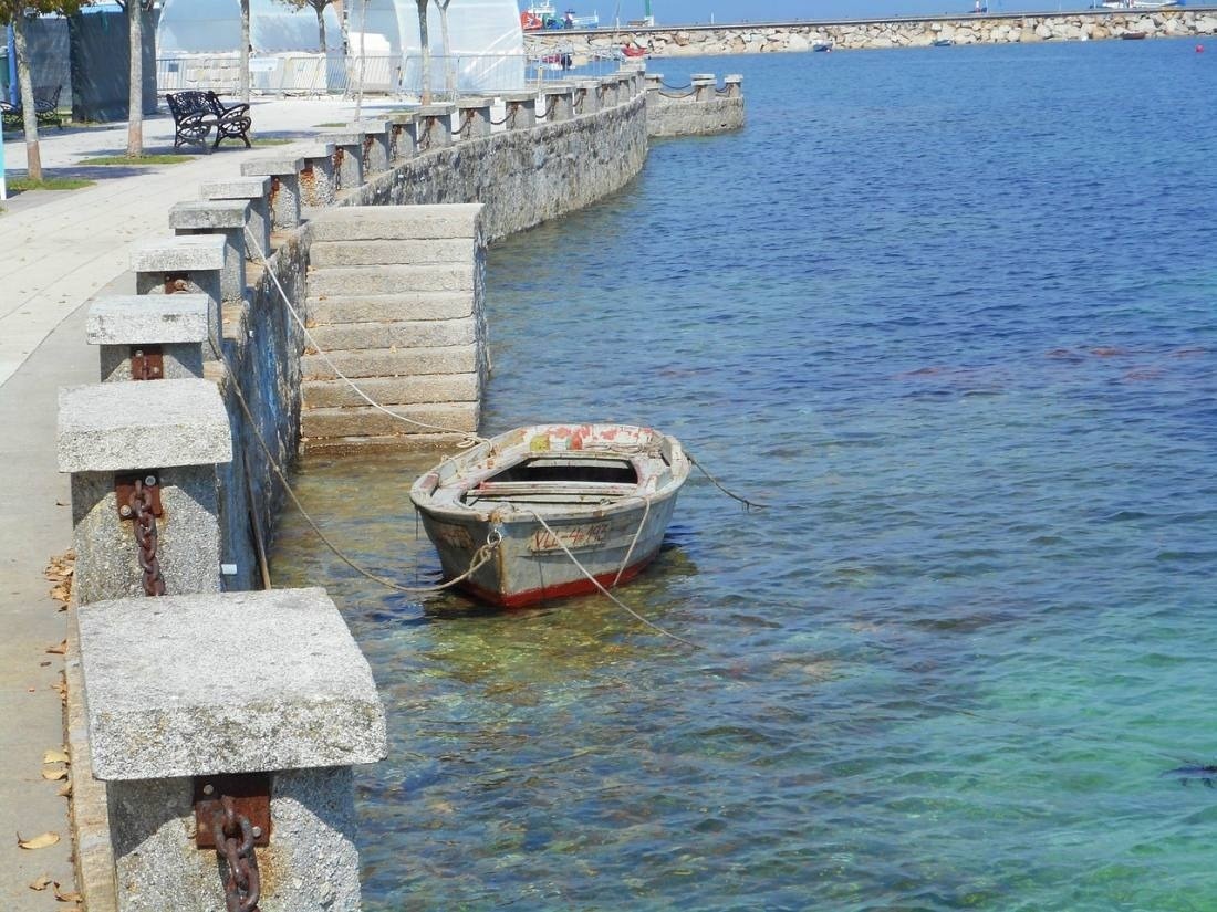 a boat is tied to a stone wall in the water