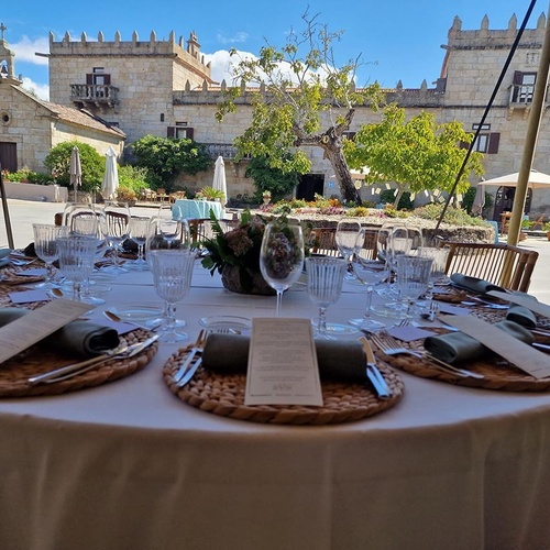 una mesa con platos y copas en frente de un castillo