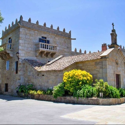 a stone building with a balcony and a statue on top of it