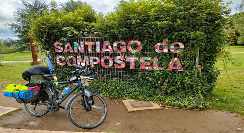 a person riding a bike down a road with trees in the background