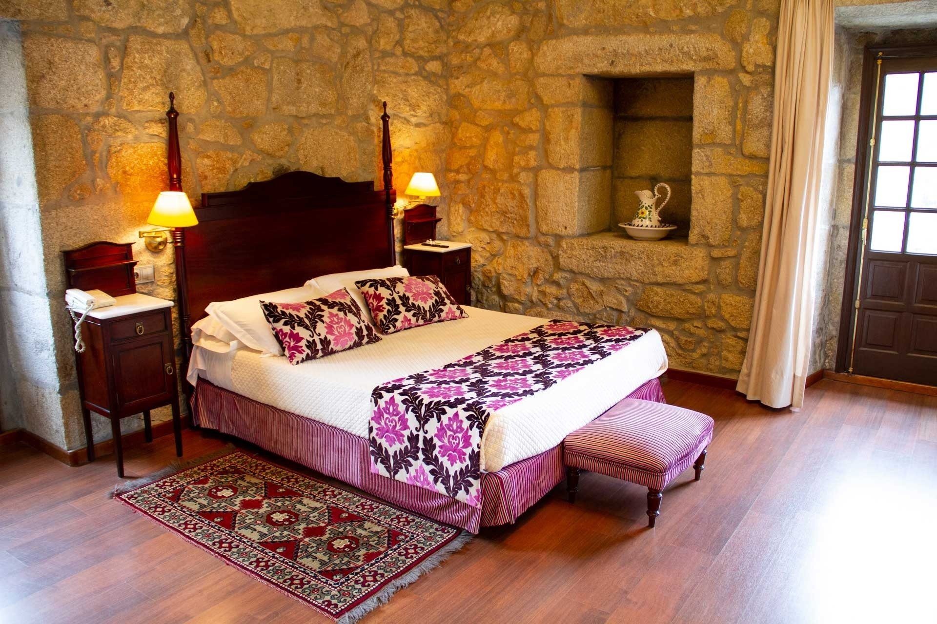 una habitación con una cama y una alfombra en el suelo