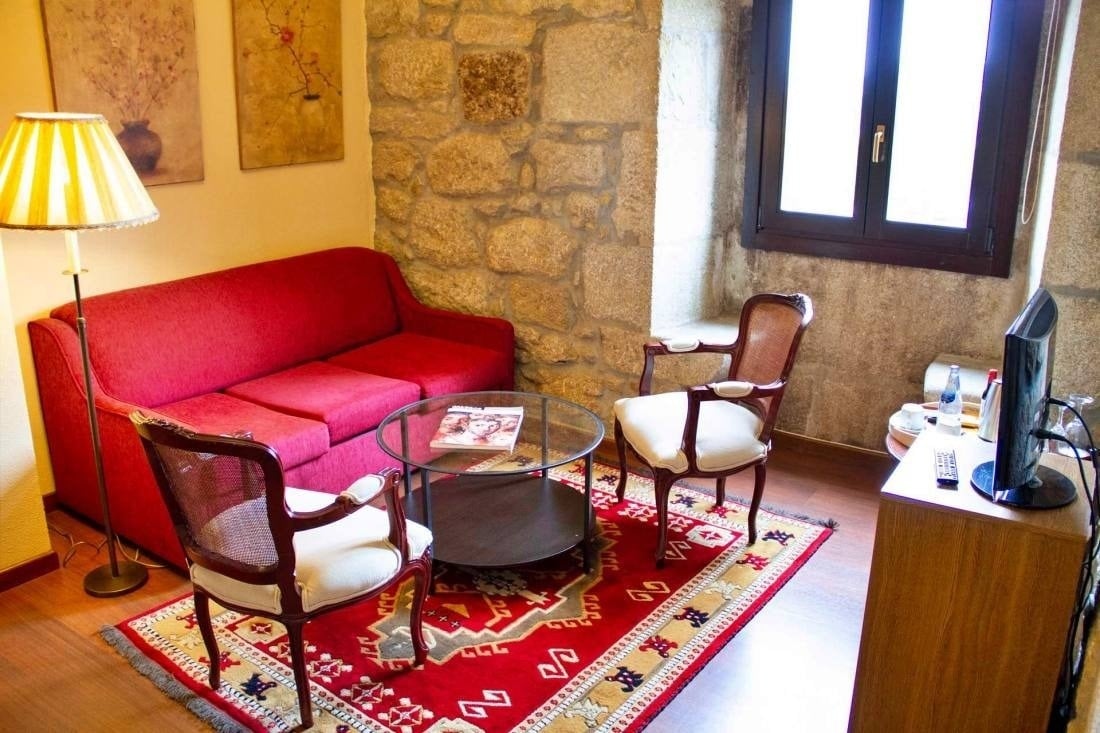 a living room with a red couch and two chairs