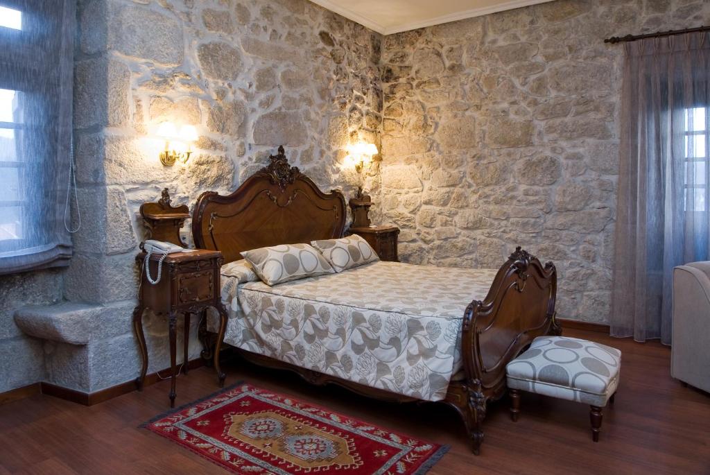Suite principal de Pazo O Rial, cama de madera, cisnes de toalla, ambiente acogedor.
