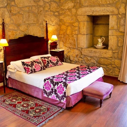a bedroom with a large bed and a rug on the floor