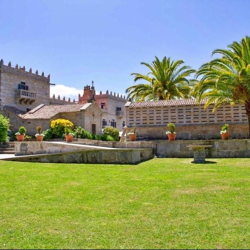 a large building with a balcony and palm trees in front of it