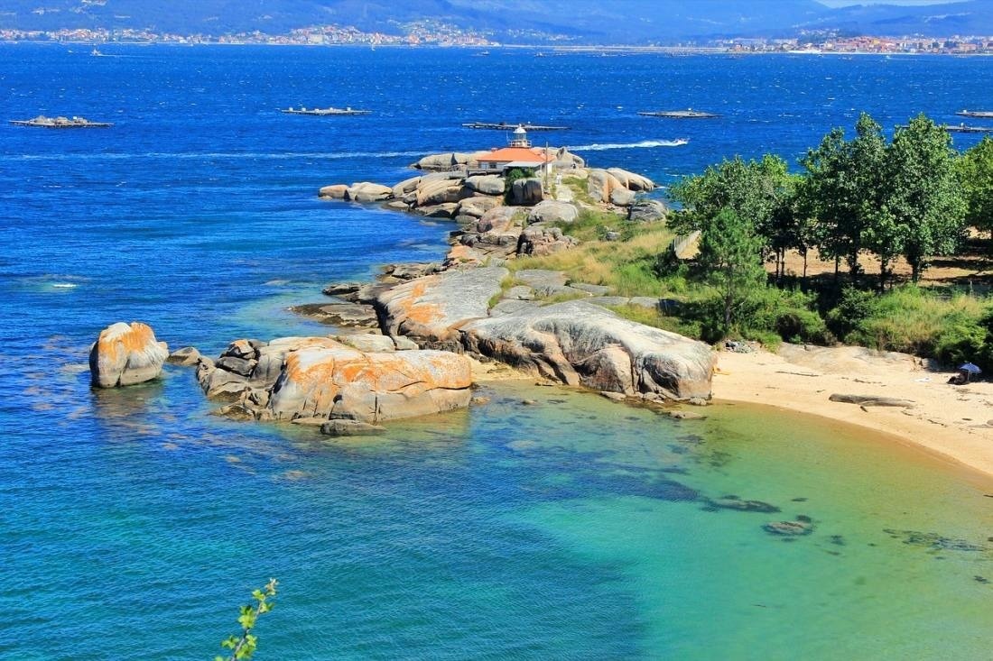 un faro en una pequeña isla en medio del océano