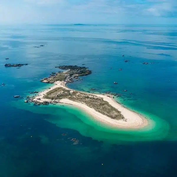 a lighthouse sits on a small island in the middle of the ocean