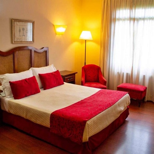 una habitación de hotel con una cama y dos sillas