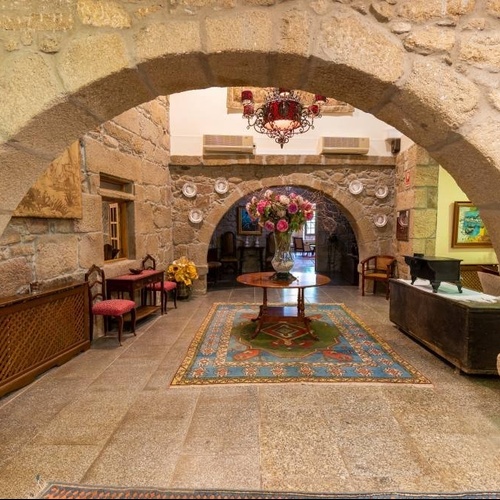 a stone archway leads to a room with a table and chairs