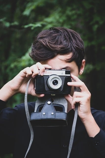 a young man is taking a picture with a kodak camera