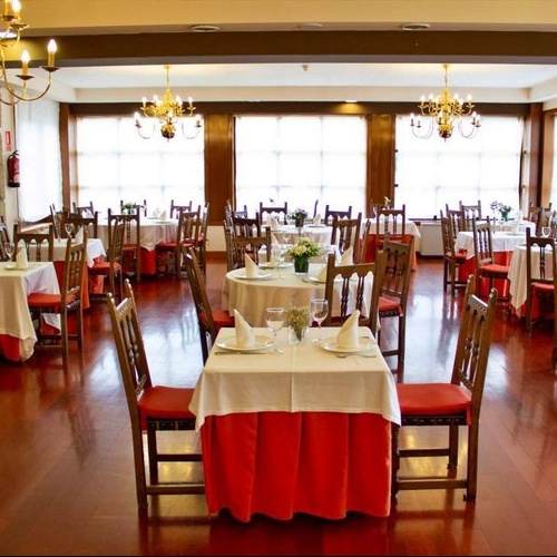 un restaurante lleno de mesas y sillas con sábanas rojas