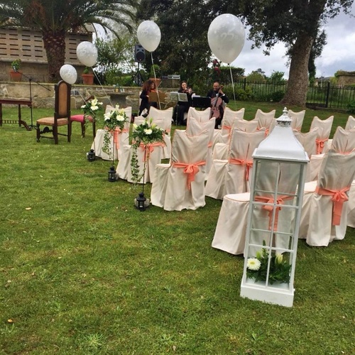 una fila de sillas decoradas para una ceremonia de boda al aire libre