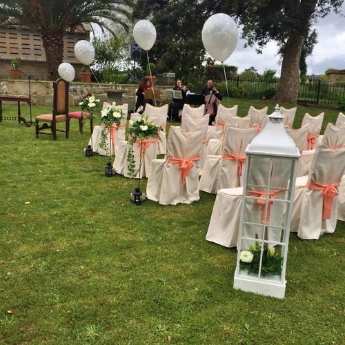 une rangée de chaises avec des rubans roses et des ballons blancs