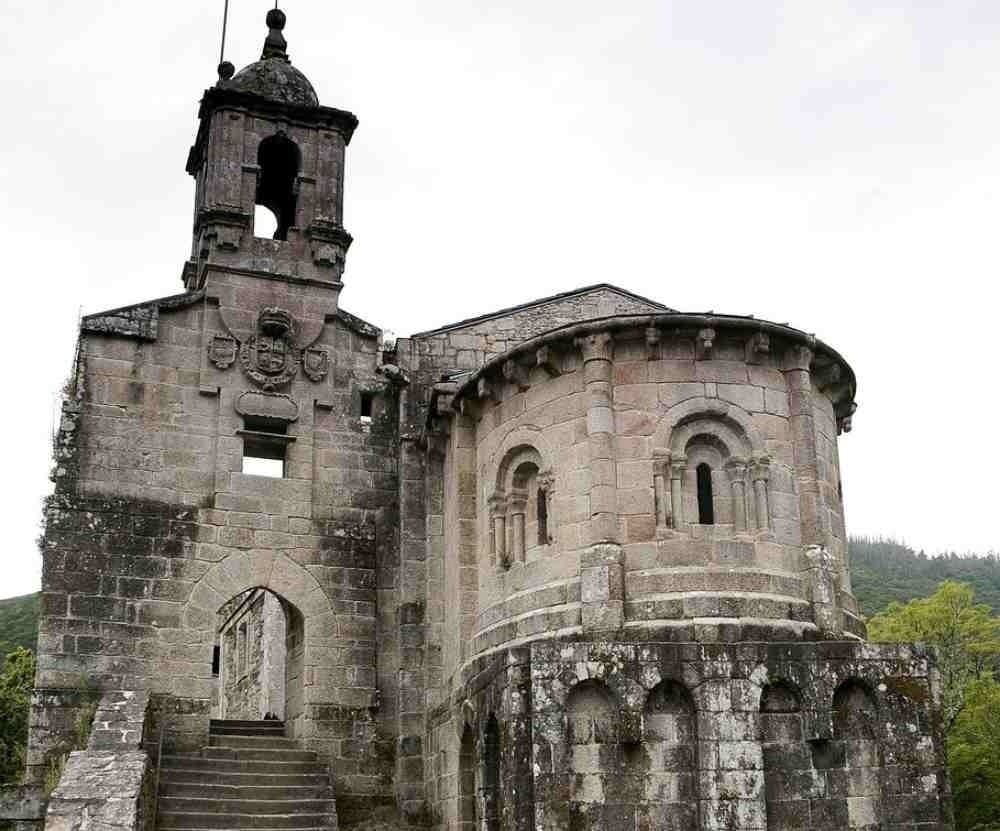un gran edificio de piedra con balcones y mesas y sillas al frente