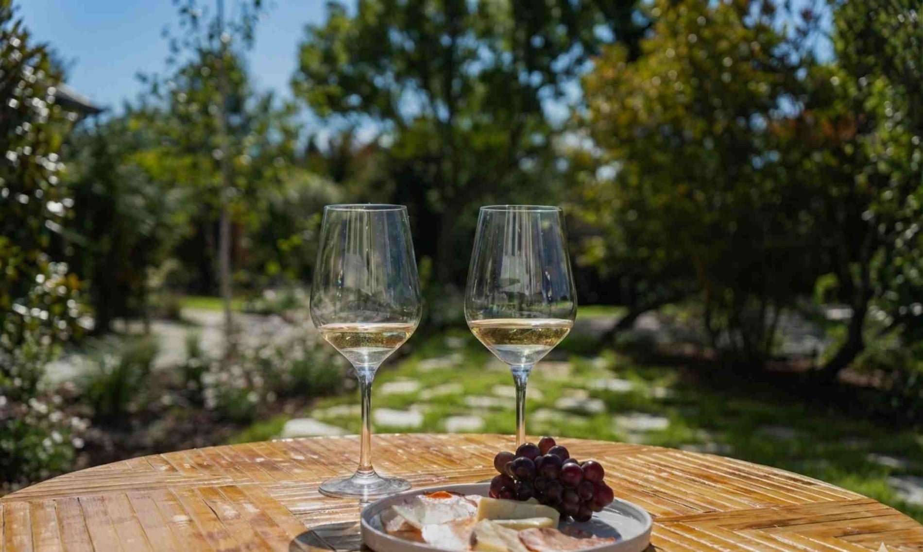 un camino a través de un parque con un banco y una farola