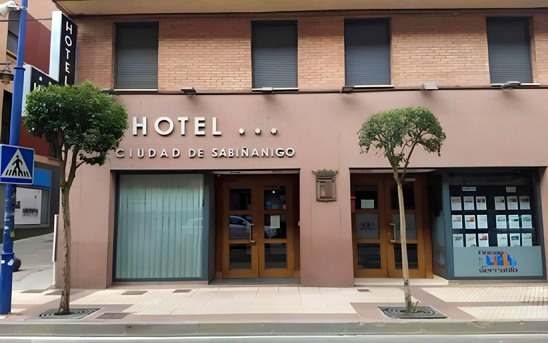 un edificio blanco con balcones y flores moradas