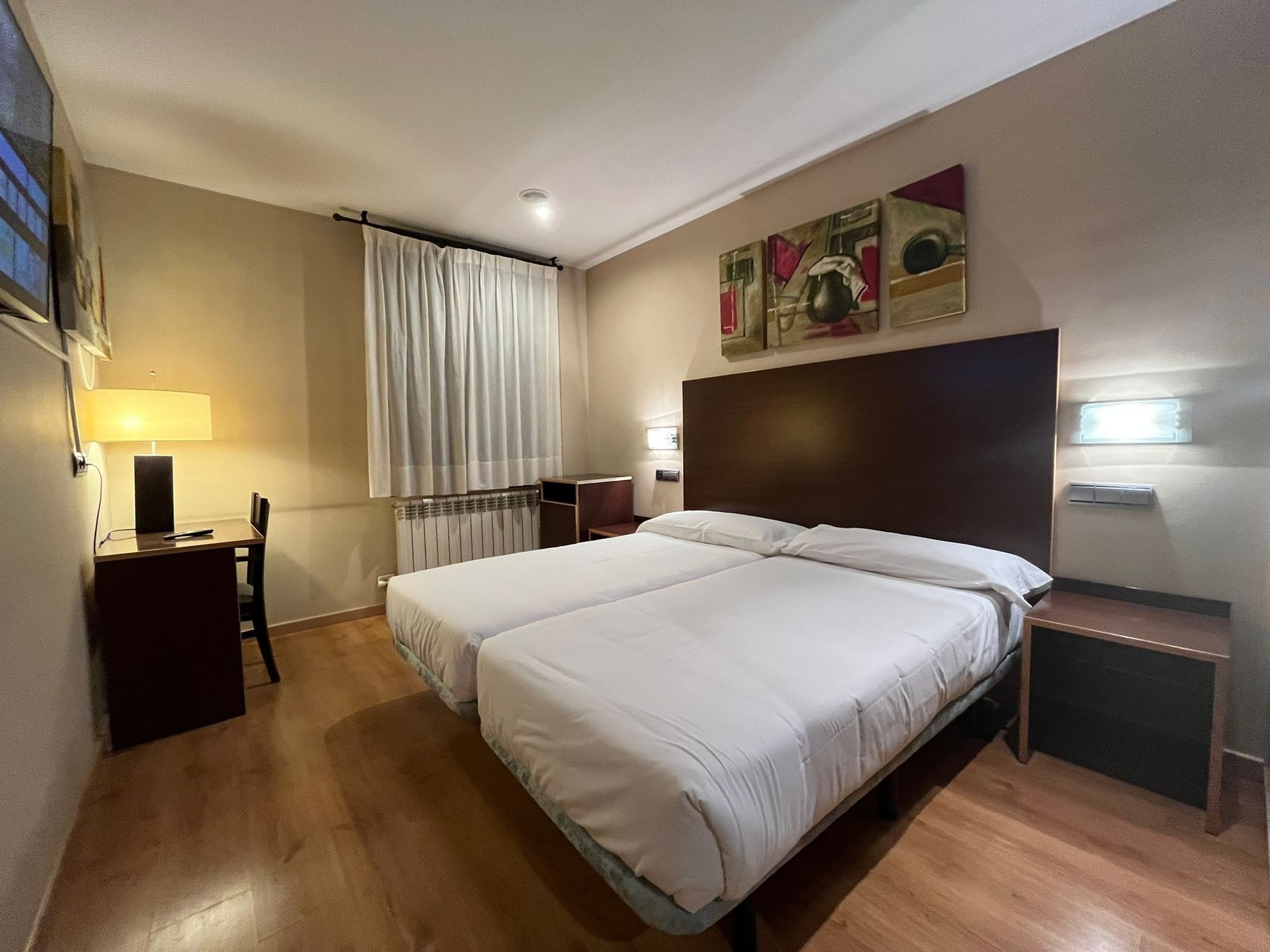 una habitación con una cama y un escritorio con una televisión