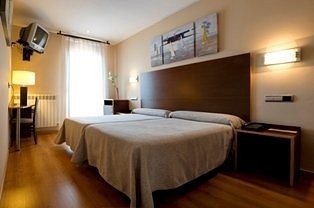 una habitación de hotel con dos camas y una televisión .