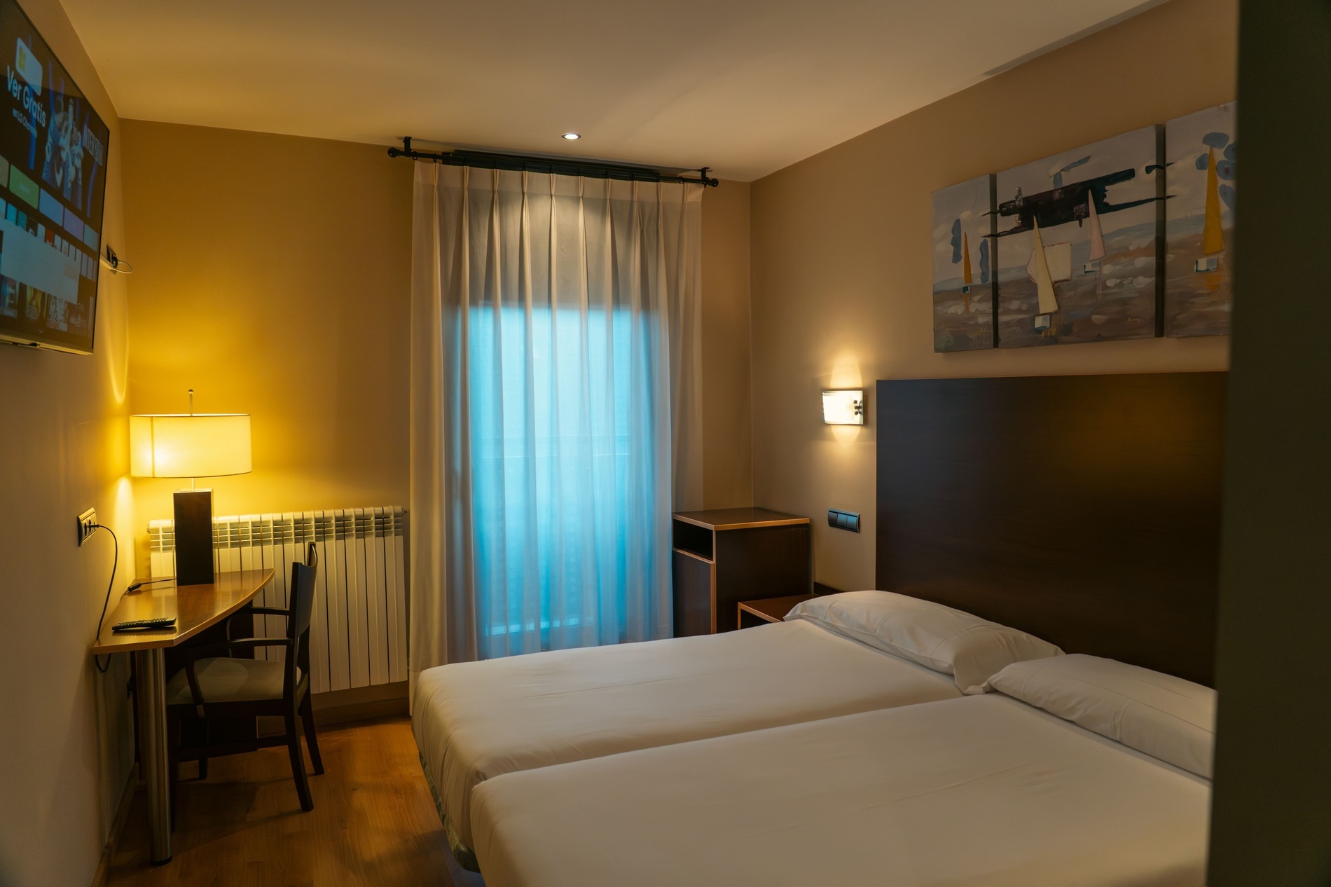 una habitación con una cama y un escritorio con una televisión