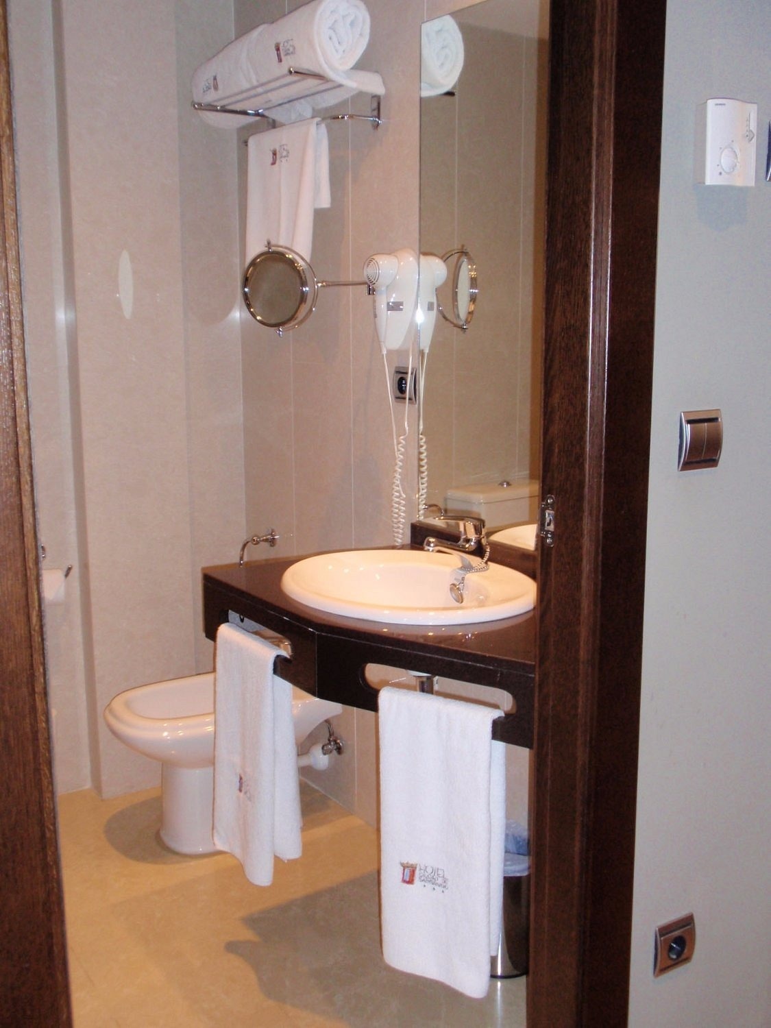 un cuarto de baño con toallas blancas y un lavabo